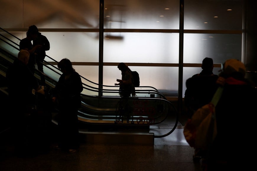 People ride an escalator at the Aeroparque International Jorge Newbery airport as Argentine air traffic controllers strike for improved working conditions and higher wages, in Buenos Aires, Argentina, August 26, 2025. REUTERS/Agustin Marcaria