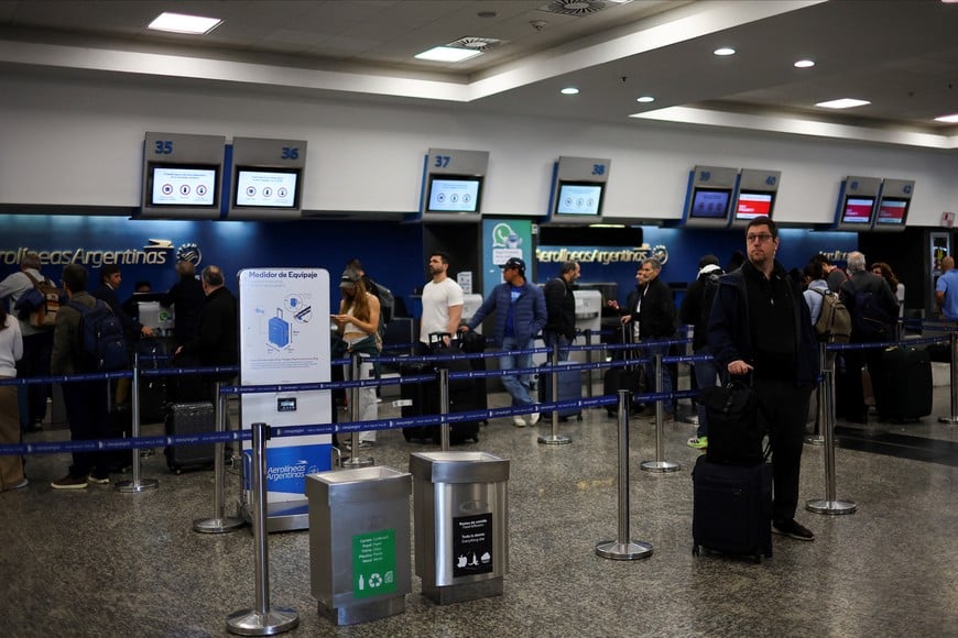 A man stands near Aerolineas Argentinas counters at the Aeroparque International Jorge Newbery airport as Argentine air traffic controllers strike for improved working conditions and higher wages, in Buenos Aires, Argentina, August 26, 2025. REUTERS/Agustin Marcaria