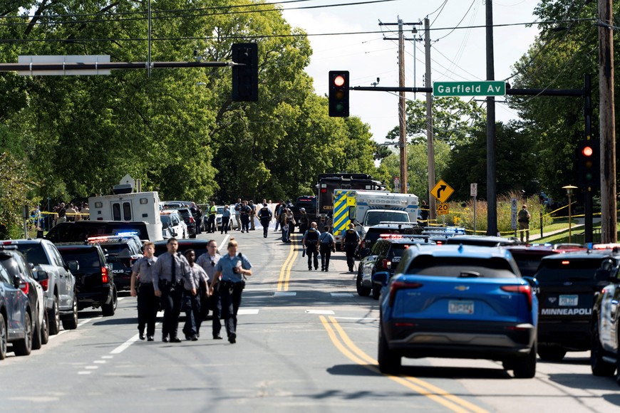 Law enforcement walk along W 54th Street, after a shooting at Annunciation Church, which is also home to an elementary school, in Minneapolis, Minnesota, U.S. August 27, 2025. REUTERS/Tim Evans