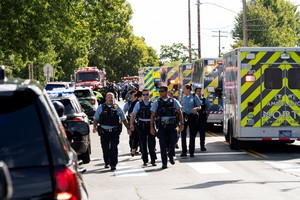 Law enforcement walk past a row of ambulances, after a shooting at Annunciation Church, which is also home to an elementary school, in Minneapolis, Minnesota, U.S. August 27, 2025.  REUTERS/Tim Evans