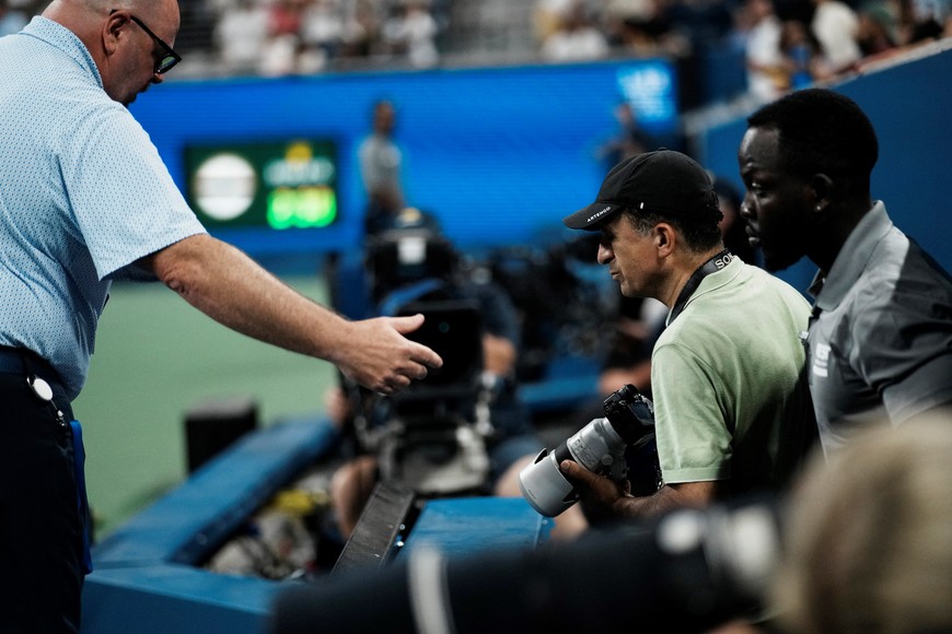 Tennis - U.S. Open - Flushing Meadows, New York, United States - August 24, 2025
A staff member escorts a photographer out during the match between France's Benjamin Bonzi and Russia's Daniil Medvedev REUTERS/Eduardo Munoz