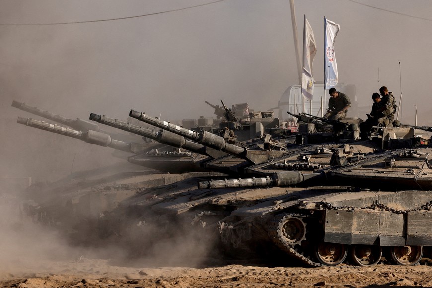 FILE PHOTO: Israeli soldiers sit on top of tanks at the Israel-Gaza border, as seen from Israel, August 26, 2025. REUTERS/Amir Cohen/File Photo
