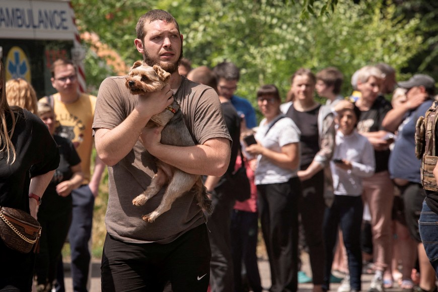 A man carries a dog as residents gather near an apartment building that was damaged during a Russian missile strike, amid Russia's attack on Ukraine, in Dnipro, Ukraine June 24, 2025. REUTERS/Mykola Synelnykov     TPX IMAGES OF THE DAY