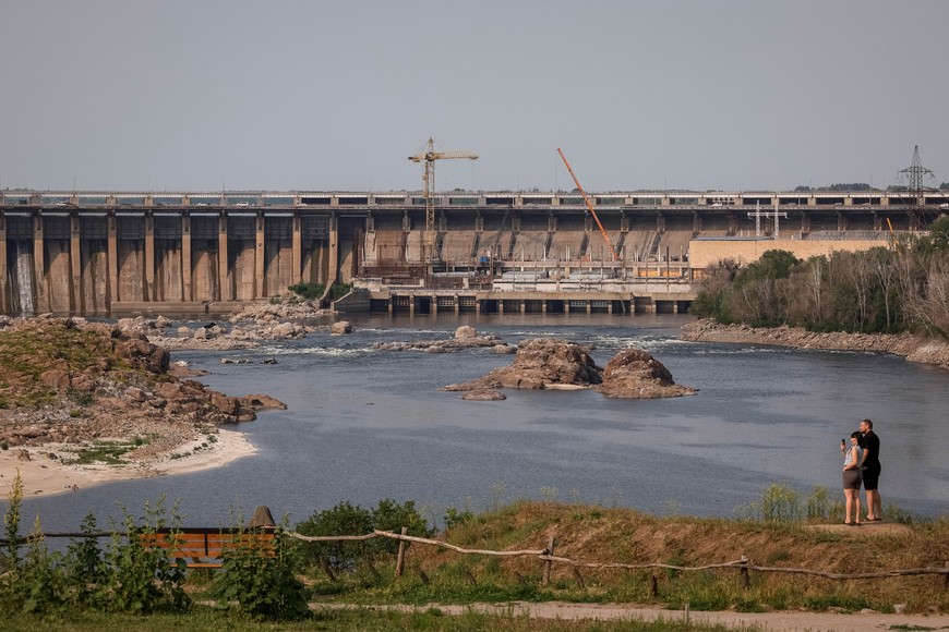 People observe the Dnipro Hydroelectric Station from the Khortytsia National Reserve park in Zaporizhzhia, Ukraine June 5, 2025. River water levels sharply dropped after an explosion at the Kakhovka dam in June 2023.  REUTERS/Alina Smutko   To match Special Report UKRAINE-CRISIS/ENERHODAR