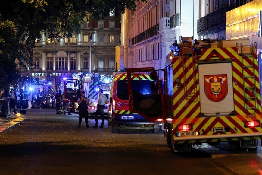 Police officers stand next to emergency vehicles parked near the site of an accident involving Lisbon's Gloria funicular, a popular tourist attraction, which derailed and crashed, resulting in fatalities and injuries, according to authorities, in Lisbon, Portugal, September 3, 2025. REUTERS/Pedro Rocha