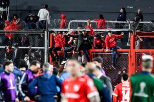 Independiente supporters climb onto stadium gates, urging police and local security to intervene in the Chile fans' area to stop them from throwing objects, before clashes broke out at the second leg of the Copa Sudamericana Round of 16 match, which was suspended due to violence in the stands, with the Chilean side leading on aggregate, in Avellaneda, Argentina August 20, 2025. REUTERS/Facundo Morales
