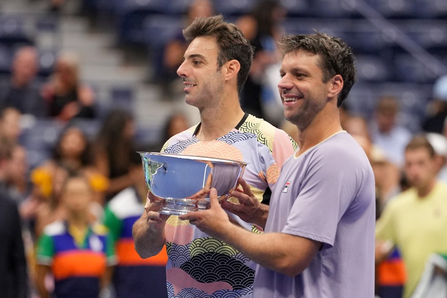 Sep 6, 2025; Flushing, NY, USA; (L-R) Marcel Granollers (ESP) and Horacio Zeballos (ARG) celebrate with the championship trophy after their match against Joe Salisbury (GBR) and Neal Skupski (GBR) (both not pictured) in the men's doubles final of the 2025 US Open tennis championships at Billie Jean King National Tennis Center. Mandatory Credit: Robert Deutsch-Imagn Images