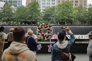 U.S. national flags and flowers are placed at the 9/11 Memorial & Museum reflecting pool ahead of the 24th anniversary of the September 11, 2001 attacks on the World Trade Center, in the Manhattan borough of New York City, U.S., September 10, 2025. REUTERS/Jeenah Moon