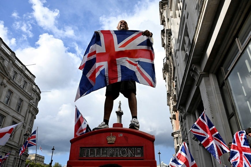 A counter protester and supporter of British anti-immigration activist Stephen Yaxley-Lennon, also known as Tommy Robinson, stands on a telephone both during a demonstration of Stand Up to Racism campaign group, in London, Britain, September 13, 2025. REUTERS/Chris J. Ratcliffe     TPX IMAGES OF THE DAY