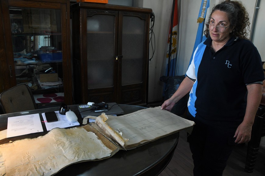 La directora Zaida Abdala muestra uno de los primeros libros de actas de la institución recuperados del olvido. Crédito: Luis Cetraro