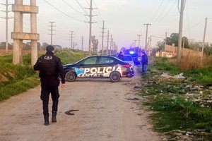 Peritos de Criminalística trabajando en la escena del hecho durante la mañana del sábado. 