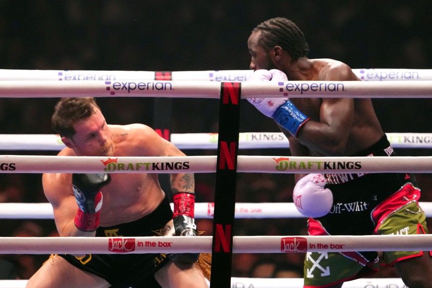 Sep 13, 2025; Las Vegas, Nevada, USA; Canelo Alvarez (black/gold trunks) and Terence Crawford (black/red trunks) box during their super middleweight title bout  at Allegiant Stadium. Mandatory Credit: Joe Camporeale-Imagn Images