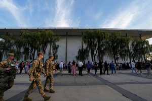 Members of the military walk as people queue to attend a vigil for conservative activist Charlie Kirk, who was fatally shot during an event at Utah Valley University, at the Kennedy Center in Washington, D.C., U.S., September 14, 2025. REUTERS/Elizabeth Frantz