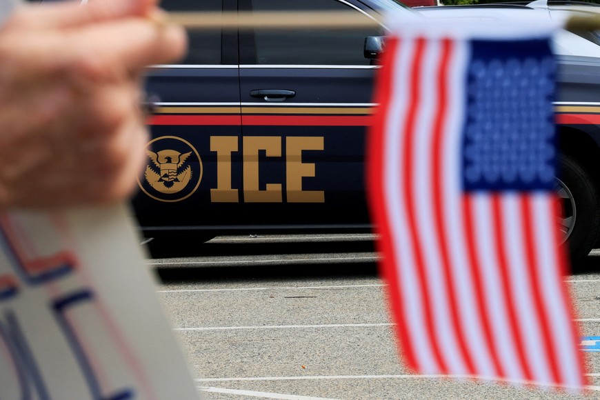 A demonstrator holds a U.S. flag outside an Immigration and Customs Enforcement (ICE) facility in Burlington, Massachusetts, U.S., September 17, 2025.   REUTERS/Brian Snyder