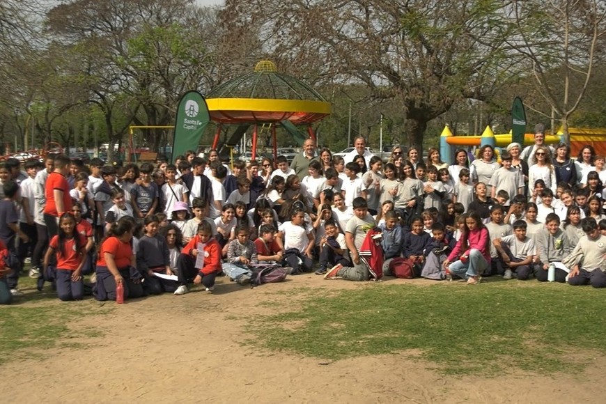Docentes y directivos acompañando a los chicos mientras presentan sus trabajos escolares.