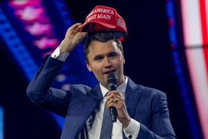 FILE PHOTO: Charlie Kirk, Turning Point USA founder, puts on a MAGA hat during the AmericaFest 2024 conference sponsored by conservative group Turning Point in Phoenix, Arizona, U.S. December 19, 2024.  REUTERS/Cheney Orr/File Photo