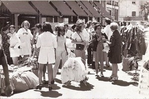 Cerca de la década del 70. Alumnado y profesoras de la escuela ofrecen ventas de prendas en la intersección de calle San Martín y la cortada Falucho. A la izquierda, los toldos que pertenecían a casa "Preston" y "El Sportsman" (a la derecha). Imagen del archivo de la Escuela Nº 637 Domingo Cullen.  Gentileza