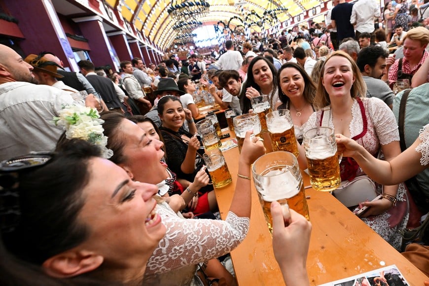 Visitors raise their beer mugs during the official opening day of the 190th Oktoberfest, the world's largest beer festival in Munich, Germany, September 20, 2025. REUTERS/Angelika Warmuth