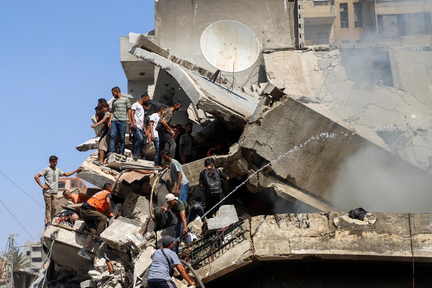 Palestinians search for victims at a residential building hit in an Israeli strike, amid an Israeli military operation, in Gaza City September 22, 2025. REUTERS/Ebrahim Hajjaj