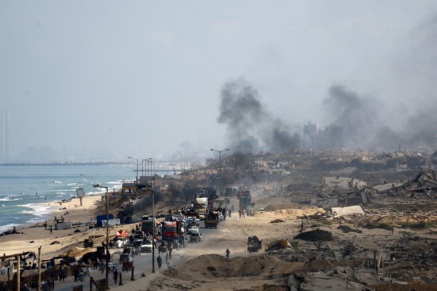 Displaced Palestinians, fleeing northern Gaza due to an Israeli military operation, move southward along a destroyed area after Israeli forces ordered residents of Gaza City to evacuate to the south, in the central Gaza Strip, September 23, 2025. REUTERS/Mahmoud Issa     TPX IMAGES OF THE DAY