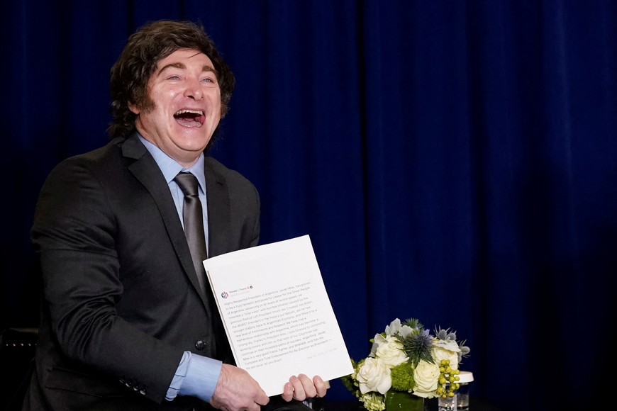 Argentina's President Javier Milei reacts while holding a document showing a Truth Social post from U.S. President Donald Trump, endorsing Milei for re-election as president, as the leaders meet during the 80th United Nations General Assembly, in New York City, New York, U.S., September 23, 2025. REUTERS/Al Drago