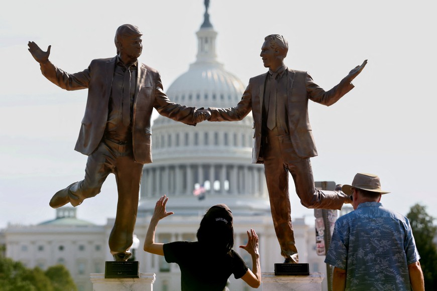 Visitors look up at a pop-up statue depicting U.S. President Donald Trump and  disgraced financier and sex offender Jeffrey Epstein dancing together near the U.S. Capitol in Washington, D.C., U.S., September 23, 2025. REUTERS/Kevin Lamarque