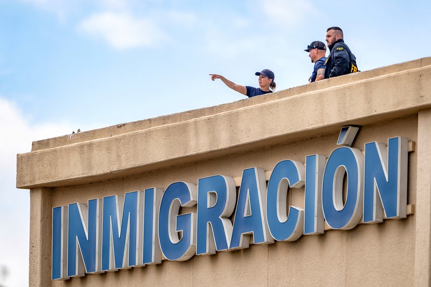 FBI agents stand on the roof of an immigration lawyer's office building across the street from the Immigration and Customs Enforcement (ICE) field office where a shooting took place, in Dallas, Texas, U.S., September 24, 2025.    REUTERS/Jeffrey McWhorter     TPX IMAGES OF THE DAY