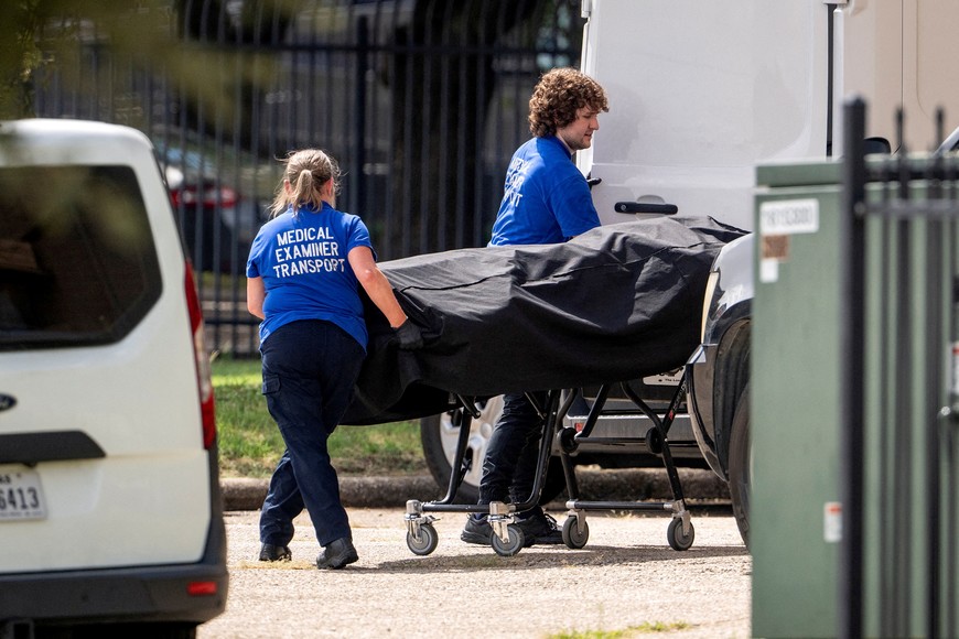 Personnel from the medical examiner's office load the body of the alleged gunman into the back of a van at the scene of a shooting at an Immigration and Customs Enforcement (ICE) field office in Dallas, Texas, U.S., September 24, 2025.    REUTERS/Jeffrey McWhorter     TPX IMAGES OF THE DAY