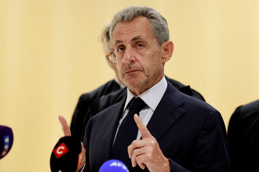 Former French President Nicolas Sarkozy talks to journalists after the verdict in his trial with other defendants on charges of corruption and illegal financing of an election campaign related to alleged Libyan funding of his successful 2007 presidential bid, at the courthouse in Paris, France, September 25, 2025. REUTERS/Stephanie Lecocq