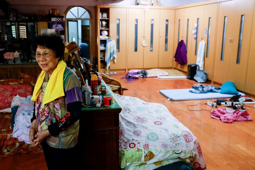 Chang Hsueh-mei, 78, stands in a temporary living space on the second floor of her home after flooding brought by Super Typhoon Ragasa in Hualien, Taiwan, September 25, 2025. REUTERS/Ann Wang