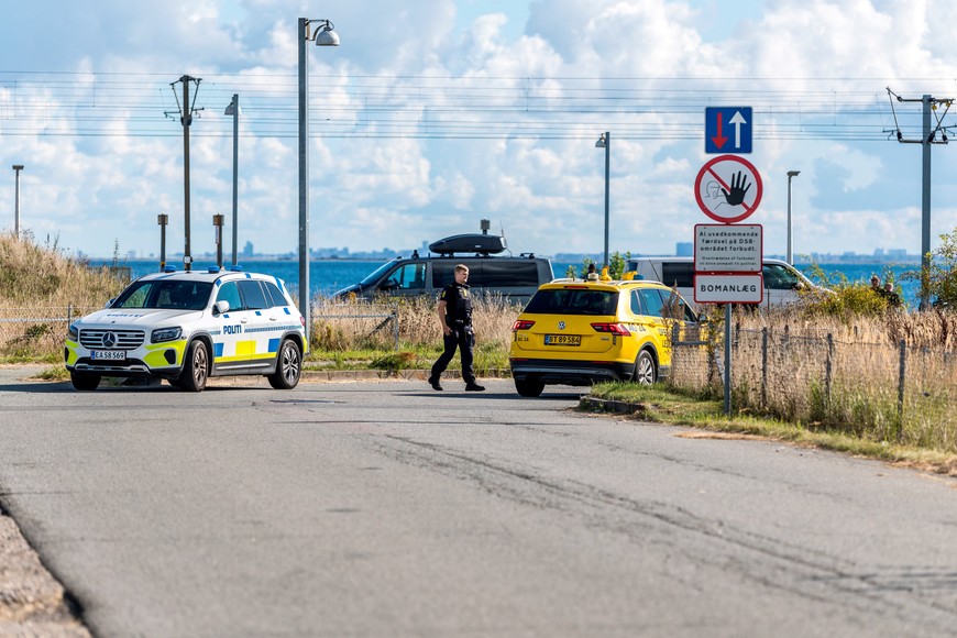 An officer walks next to vehicles following the temporary closure of airspace late on Monday after drones were observed in Danish airspace, in Copenhagen, Denmark, September 23, 2025. Ritzau Scanpix/Steven Knap/via REUTERS   ATTENTION EDITORS - THIS IMAGE WAS PROVIDED BY A THIRD PARTY. DENMARK OUT. NO COMMERCIAL OR EDITORIAL SALES IN DENMARK.