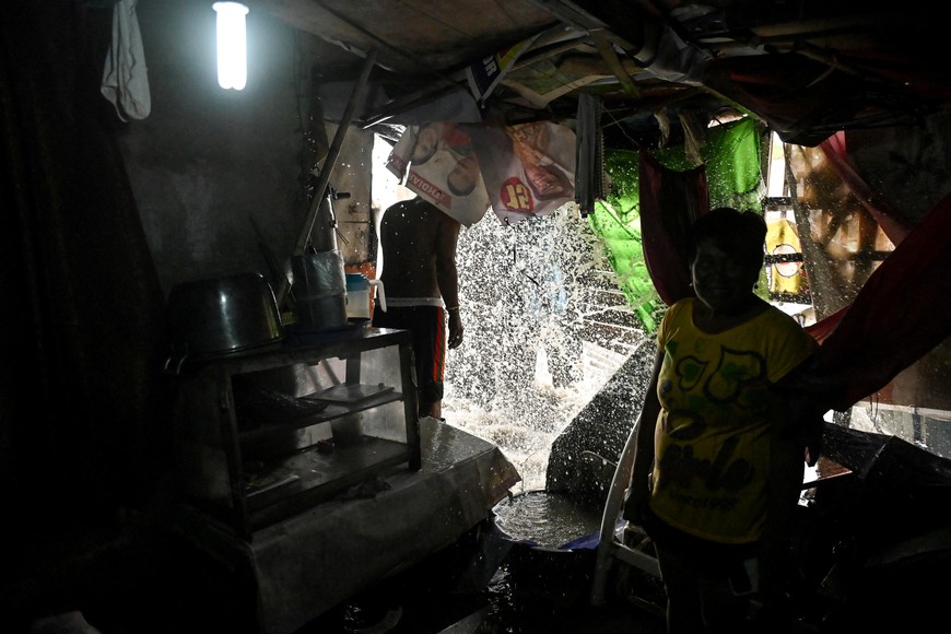 People look as waves from Laguna Lake crash into their house, intensified by Severe Tropical Storm Bualoi, in Sinalhan, Santa Rosa, Laguna province, Philippines, September 26, 2025. REUTERS/Noel Celis