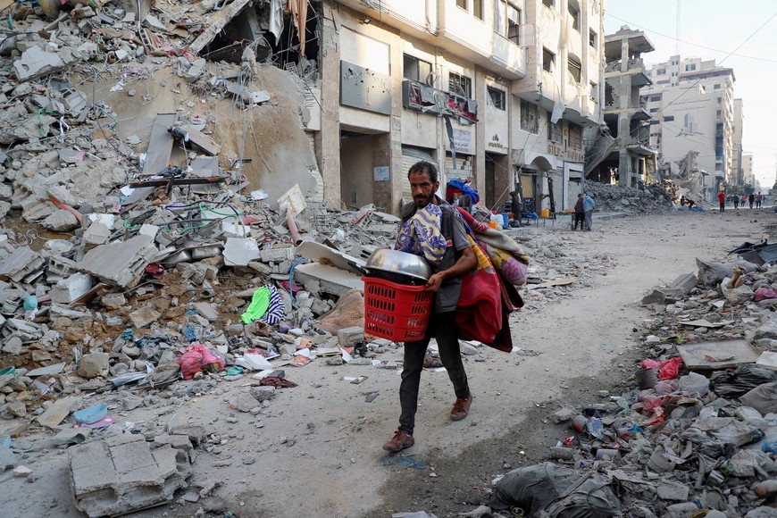 A Palestinian man carries his belongings during an Israeli military operation, after residents were ordered to evacuate Gaza City, September 29, 2025. REUTERS/Ebrahim Hajjaj     TPX IMAGES OF THE DAY