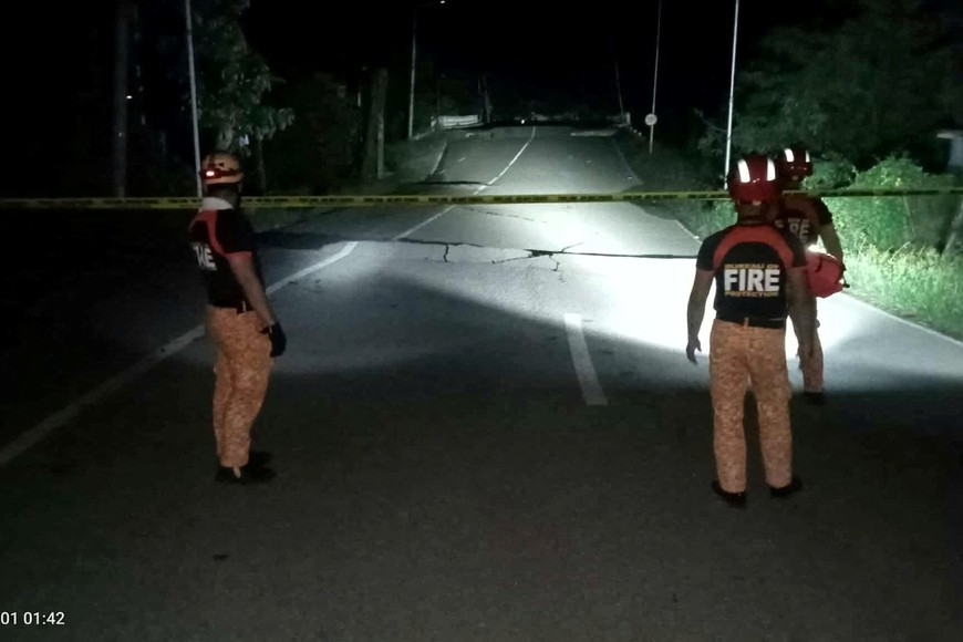 Rescue personnel stand in front of a crack in a road caused by a magnitude 6.9 quake, in Daanbantayan, Cebu Province, Philippines, October 1, 2025. Municipality of Daanbantayan/Handout via REUTERS. THIS IMAGE HAS BEEN SUPPLIED BY A THIRD PARTY. NO RESALES. NO ARCHIVE. MANDATORY CREDIT. DATE AND TIME STAMP FROM SOURCE