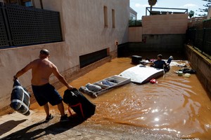 Residents remove belongings from flooded garages after storm Gabrielle hit the island, in Ibiza, Spain October 1, 2025. REUTERS/Francisco Ubilla