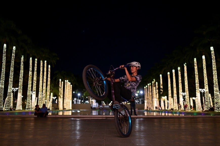 A boy rides a bikes in a public square adorned with Christmas lights as the holiday season officially begins since Venezuela's President Nicolas Maduro announced that Christmas celebrations would start in October, two months ahead of the traditional season, in Caracas, Venezuela October 1, 2025. REUTERS/Gaby Oraa