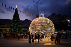 People pose with Christmas decorations in a public square as the holiday season officially begins since  Venezuela's President Nicolas Maduro announced that Christmas celebrations would start in October, two months ahead of the traditional season, in Caracas, Venezuela October 1, 2025. REUTERS/Gaby Oraa