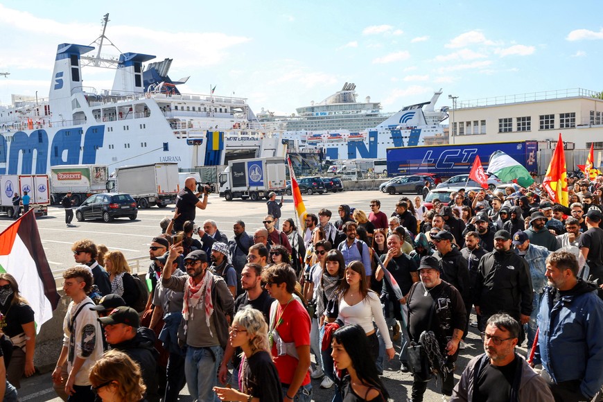 FILE PHOTO: Pro-Palestinian demonstrators walk past the touristic port as they march towards the commercial port of Naples during a nationwide strike called by the USB union to condemn the Israeli forces' interception of the vessels of the Global Sumud Flotilla aiming to reach Gaza and break Israel's naval blockade, in Naples, Italy, October 3, 2025. REUTERS/Ciro De Luca/File Photo