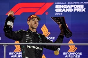 Formula One F1 - Singapore Grand Prix - Marina Bay Street Circuit, Singapore - October 5, 2025
Mercedes' George Russell celebrates on the podium with the trophy after winning the Singapore Grand Prix REUTERS/Athit Perawongmetha