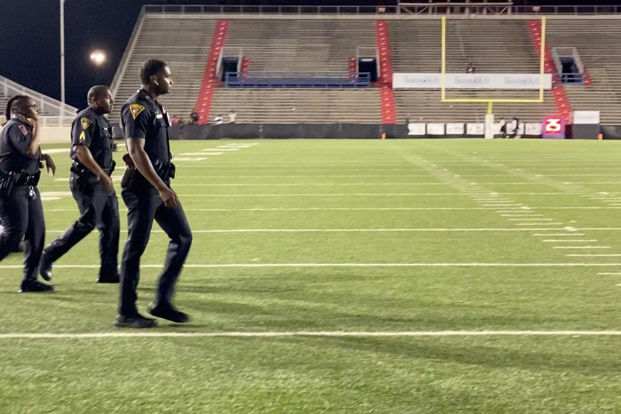 Police walk on the field following gunshots during the Vigor versus Williamson football game at Ladd-Peebles Stadium in Mobile, Alabama, U.S. October 15, 2021, in this still image taken from video obtained from social media. Video taken October 15, 2021. Mandatory credit  JEFF MARTIN/ TWITTER/via REUTERS ATTENTION EDITORS - THIS IMAGE HAS BEEN SUPPLIED BY A THIRD PARTY. MANDATORY CREDIT. NO RESALES. NO ARCHIVES.
