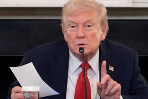 U.S. President Donald Trump holds a note that was handed to him by U.S. Secretary of State Marco Rubio during a roundtable on antifa, an anti-fascist movement Trump designated a domestic "terrorist organization" via executive order on September 22, at the White House in Washington, D.C., U.S., October 8, 2025. REUTERS/Evelyn Hockstein