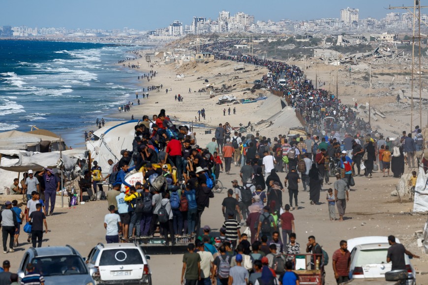Palestinians, who were displaced to the southern part of Gaza at Israel's order during the war, make their way along a road as they return to the north after a ceasefire between Israel and Hamas in Gaza went into effect, in the central Gaza Strip, October 10, 2025. REUTERS/Mahmoud Issa