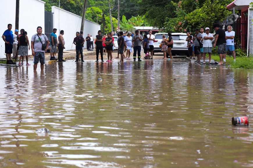 People look at a flooded street after torrential rains that caused an overflow of rivers in Poza Rica, Veracruz state, Mexico, October 10, 2025. REUTERS/Rolando Ramos