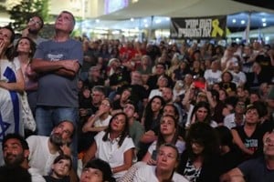 La gente aguarda frente a las pantallas gigantes en la Plaza de los Rehenes en Tel Aviv.