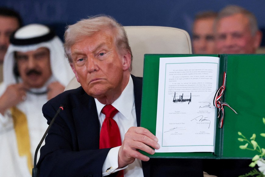 U.S. President Donald Trump poses with the signed agreement at a world leaders' summit on ending the Gaza war, amid a U.S.-brokered prisoner-hostage swap and ceasefire deal between Israel and Hamas, in Sharm el-Sheikh, Egypt, October 13, 2025. REUTERS/Suzanne Plunkett/Pool     TPX IMAGES OF THE DAY