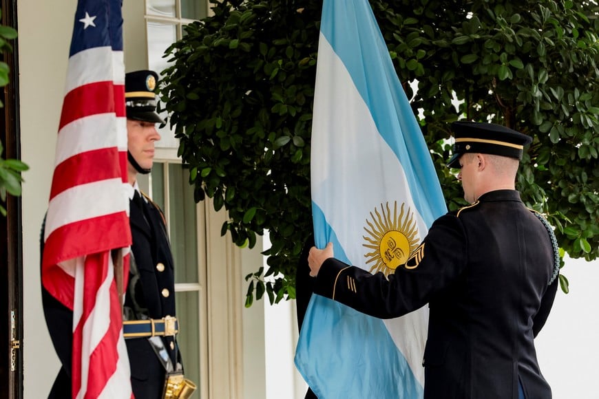 A U.S. military honor guard holds the Argentine flag next to the American flag ahead of a meeting between U.S. President Donald Trump and Argentina’s President Javier Milei at the White House in Washington, D.C., U.S., October 14, 2025. REUTERS/Jonathan Ernst
