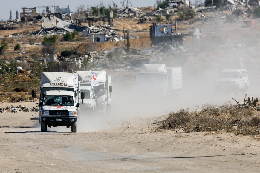 Red Cross vehicles escort trucks transporting the bodies of deceased Palestinians held by Israel during the war, after their release, amid a ceasefire between Israel and Hamas, in Khan Younis, southern Gaza Strip, October 15, 2025. REUTERS/Mahmoud Issa