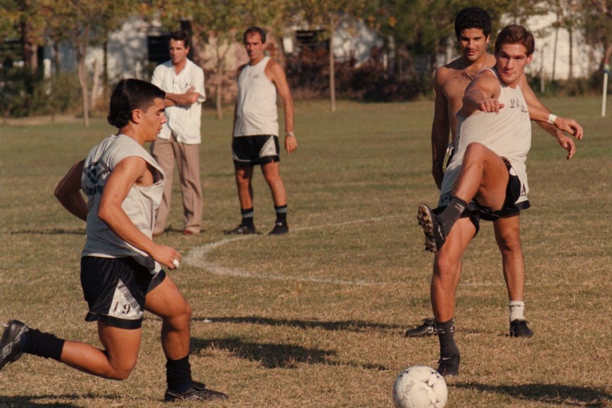 El Tuca Risso remata, Saralegui observa y, más atrás, Pancho Ferraro mira atentamente la jugada en el predio del SAT.