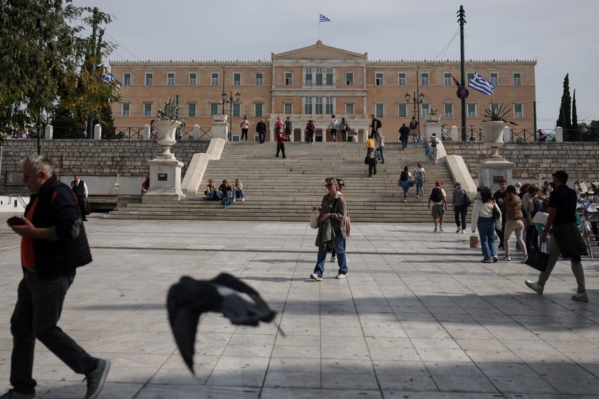 People walk near the Greek parliament, after lawmakers approved a government bill allowing the extension of working hours in the private sector, in Athens, Greece, October 16, 2025. REUTERS/Louisa Gouliamaki