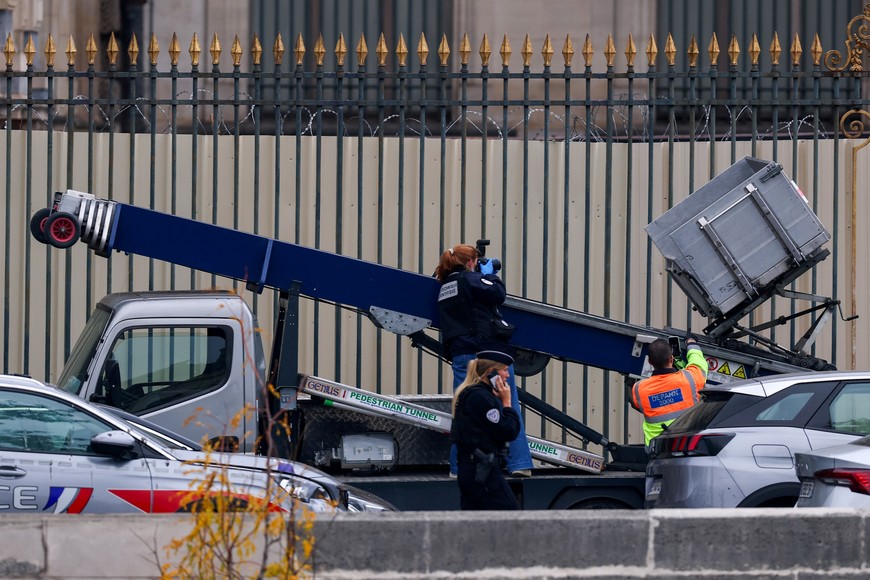 Police officers work at a crane believed to have been used in what the French Interior Ministry said was a robbery at the Louvre museum during which jewellery was stolen, in Paris, France, October 19, 2025. REUTERS/Gonzalo Fuentes